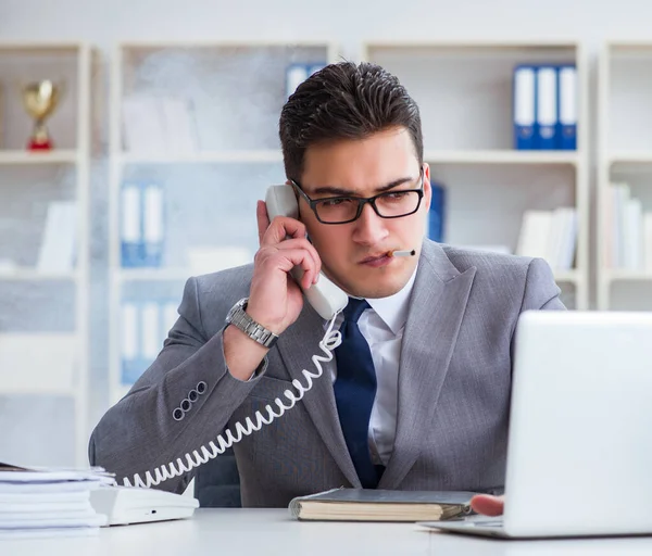 Businessman smoking in office at work — Stock Photo, Image