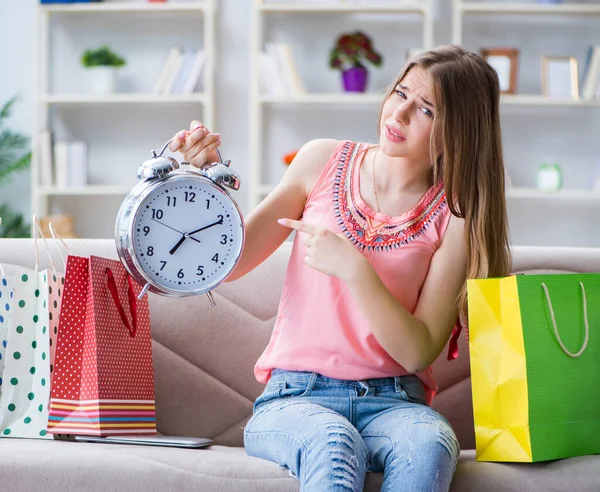 Młoda kobieta z torbami na zakupy w domu na kanapie — Zdjęcie stockowe