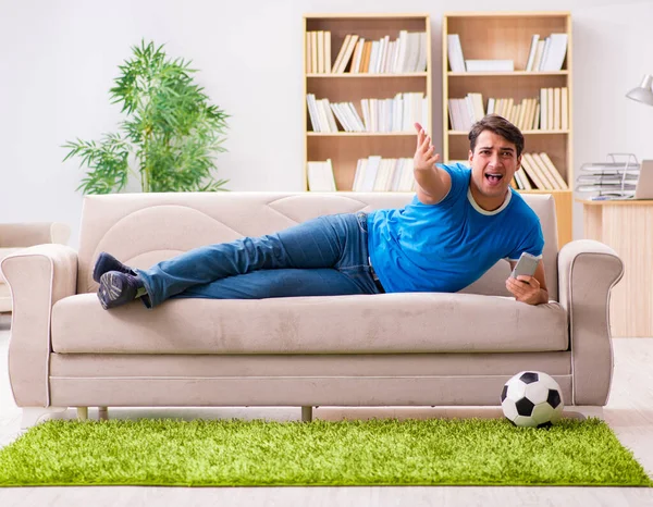 Homme regardant le football à la maison assis dans le canapé — Photo