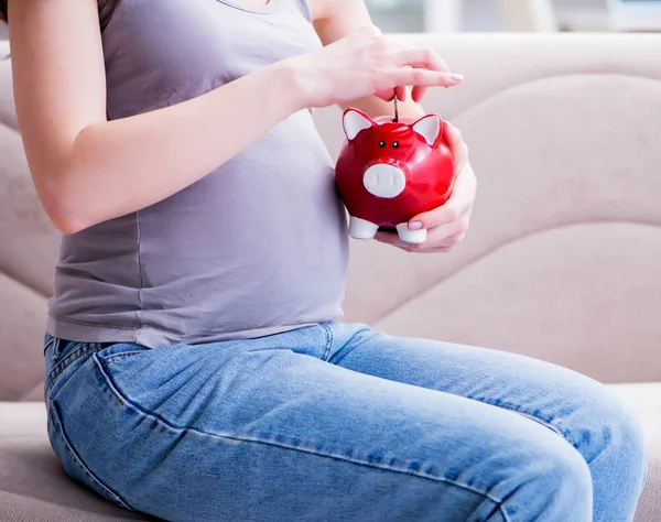 Těhotná žena s břichem bříškem sedí na pohovce doma — Stock fotografie
