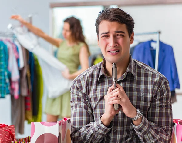 Мужчина сыт по горло покупками жены в магазине — стоковое фото
