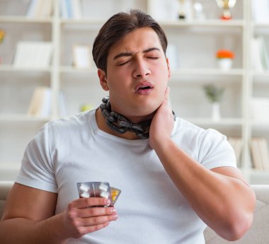 Genç adam boğaz ağrısı çekiyor.