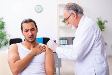 Genç erkek hasta, deneyimli doktoru ziyaret ediyor.