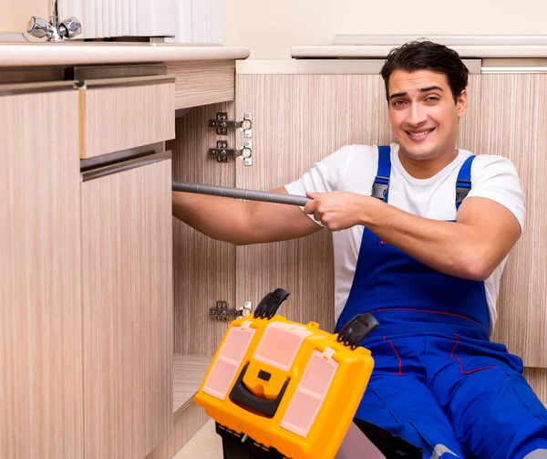 Jonge reparateur werkt in de keuken — Stockfoto