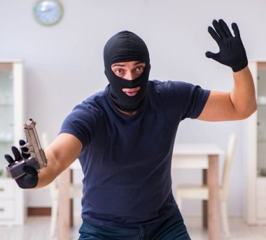 Soyguncu kar maskesi takıp değerli şeyler çalıyor.
