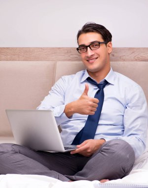 İş adamı evdeki yatakta çalışıyor.