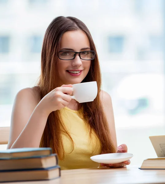 Jovem estudante bebendo café enquanto subitamente — Fotografia de Stock