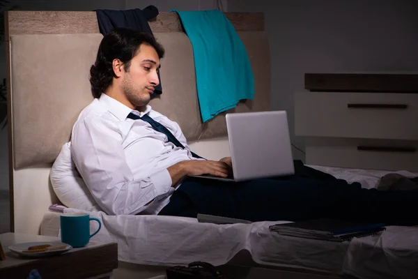 Jovem funcionário trabalhando em casa após o turno da noite — Fotografia de Stock