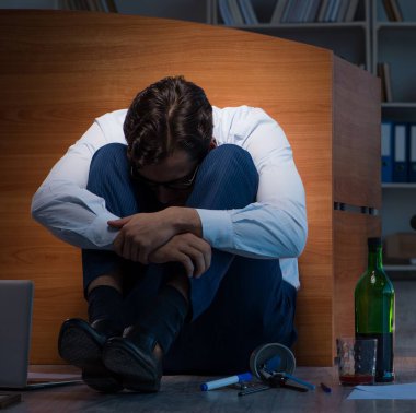 Stresli iş adamı depresyonda fazla mesai yapıyor.