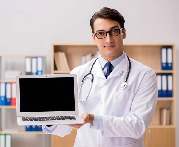 Médico adulto joven con computadora portátil — Foto de Stock