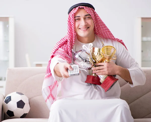 Hombre árabe joven viendo fútbol sentado en el sofá — Foto de Stock