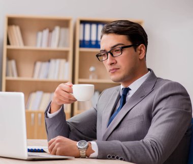 Genç yakışıklı işadamı ofiste çalışıyor.