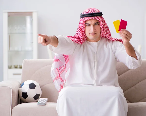 Hombre árabe joven viendo fútbol sentado en el sofá —  Fotos de Stock