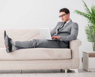 Genç işadamı kanepede yatıyor.