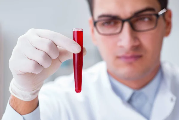 Médico joven en el laboratorio con tubo rojo — Foto de Stock