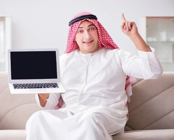 年轻的阿拉伯商人在沙发上与笔记本电脑打交道 — 图库照片