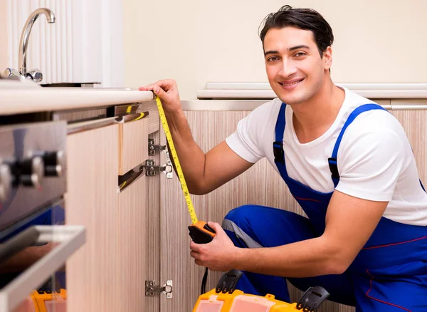 Junger Reparateur arbeitet in der Küche — Stockfoto