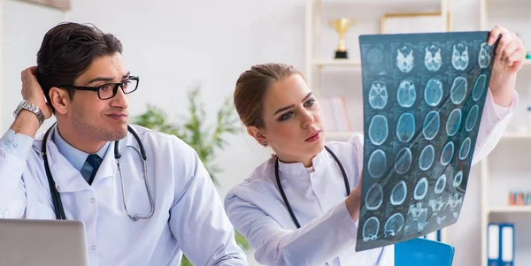 Два лікарі вивчають рентгенівські знімки пацієнта для діагностики — стокове фото