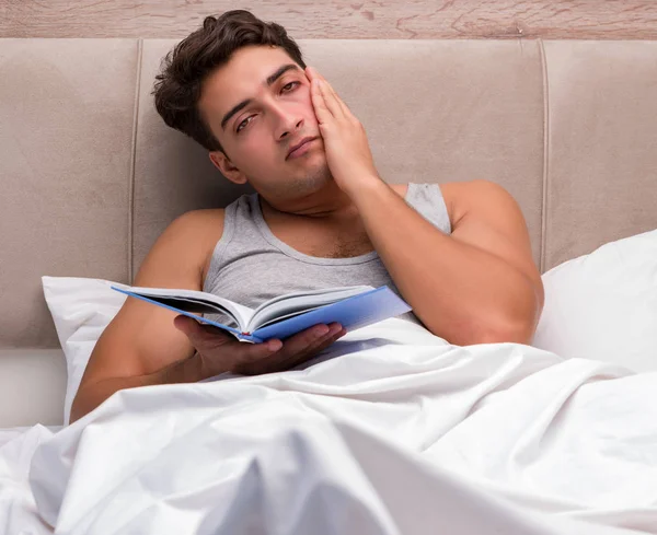 Homem leitura livro na cama — Fotografia de Stock