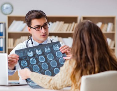 Genç doktor bilgisayardaki röntgen görüntülerine bakıyor.