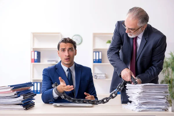 Oude baas en jonge mannelijke werknemer in het kantoor — Stockfoto