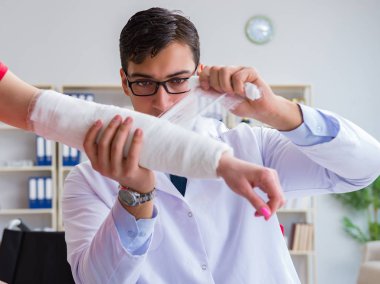 Hastanede yaralanma kontrolü sırasında doktor ve hasta.