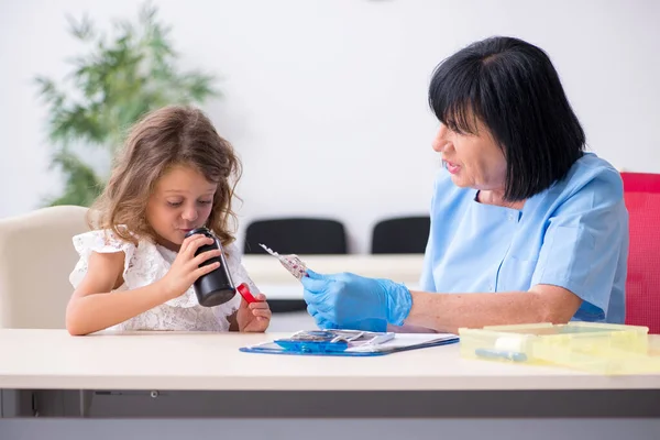 Bambina in visita vecchio medico femminile — Foto Stock