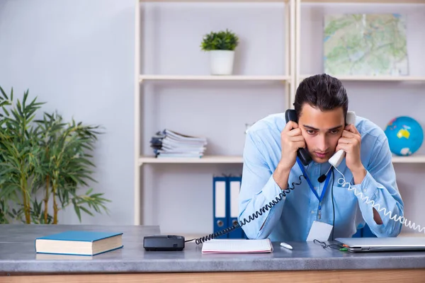 Giovane agente di viaggio maschile che lavora in ufficio — Foto Stock