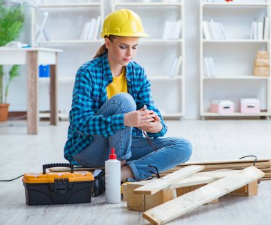 Tamirci kadın marangoz ahşap döşemeleri kesiyor.