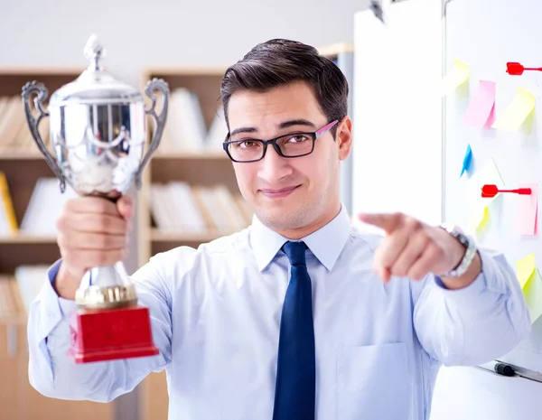 Young businessman receiving prize cup in office — Stock Photo, Image