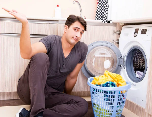 Молодий чоловік робить прання вдома — стокове фото