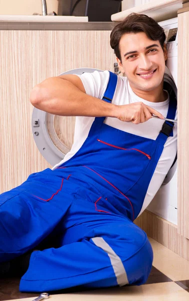 Reparateur repareert wasmachine in de keuken — Stockfoto