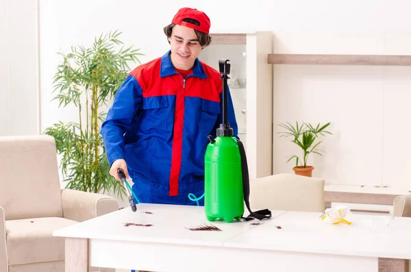 Jovem empreiteiro fazendo controle de pragas em casa — Fotografia de Stock