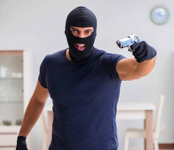 Ladrão usando balaclava roubando coisas valiosas — Fotografia de Stock