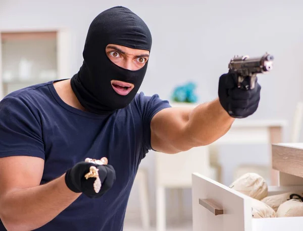 Ladrão usando balaclava roubando coisas valiosas — Fotografia de Stock