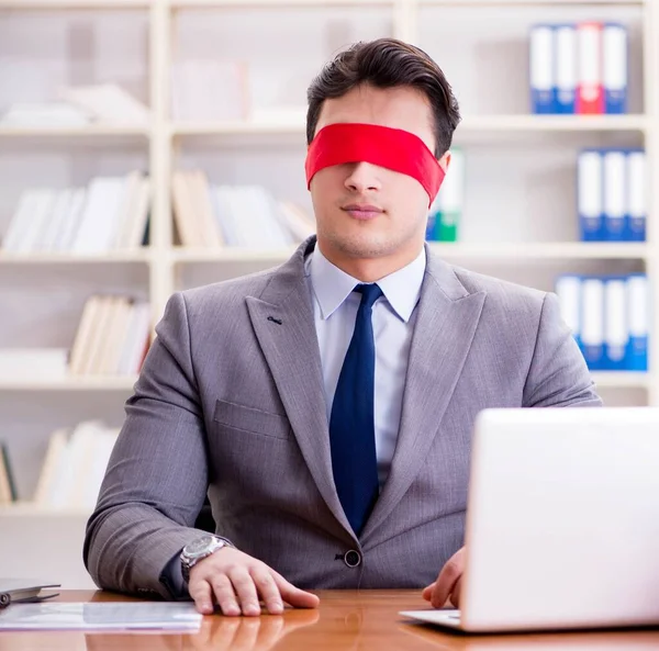 Ofiste masasında oturan gözü bağlı iş adamı.