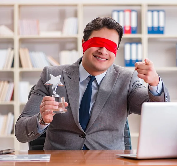 Geschäftsmann mit verbundenen Augen sitzt im Büro am Schreibtisch — Stockfoto