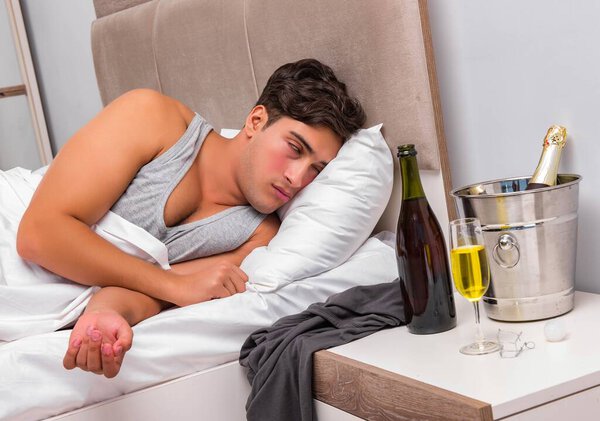 Человек в постели после вечеринки - концепция Hangover
