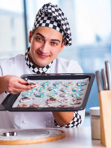 Young man cooking cookies in kitchen