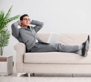Genç işadamı kanepede yatıyor.