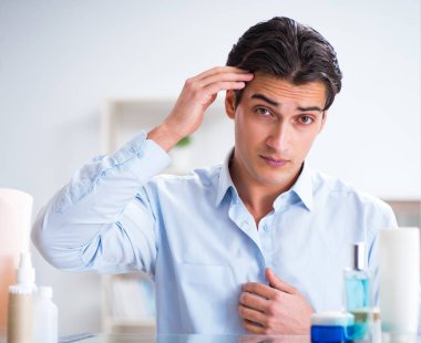 Adam banyoda çalışmak için giyiniyor.