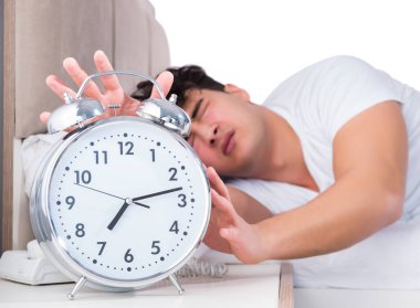 Yatakta uykusuzluk çeken bir adam.