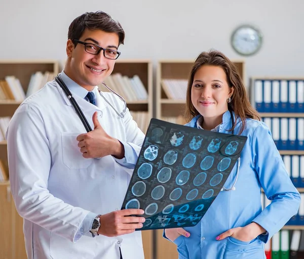 Ung läkare tittar på datortomografi röntgen bild — Stockfoto