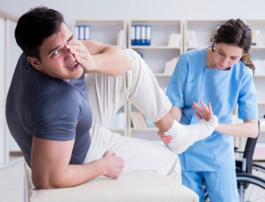 Hastanede yaralanma kontrolü sırasında doktor ve hasta.