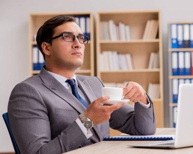 Genç yakışıklı işadamı ofiste çalışıyor.