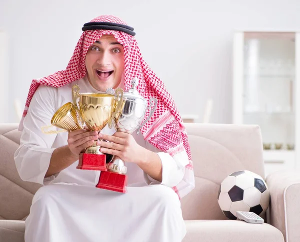 Hombre árabe joven viendo fútbol sentado en el sofá — Foto de Stock