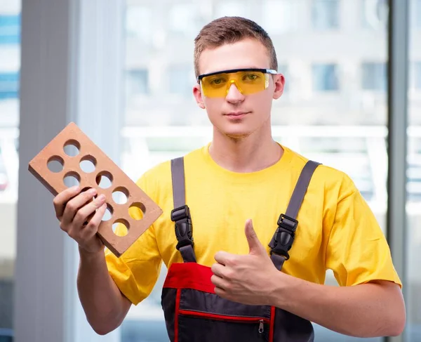 Joven trabajador de la construcción en mono amarillo — Foto de Stock