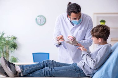 Genç çocuk hastanede doktoru ziyaret ediyor.