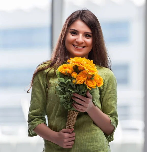 Ung flicka med present av blommor — Stockfoto