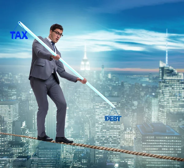 Businessman balancing between debt and tax — Stock Photo, Image